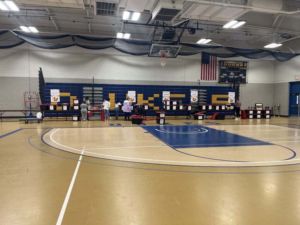 Indoor gymnasium with basketball court and decorated walls.