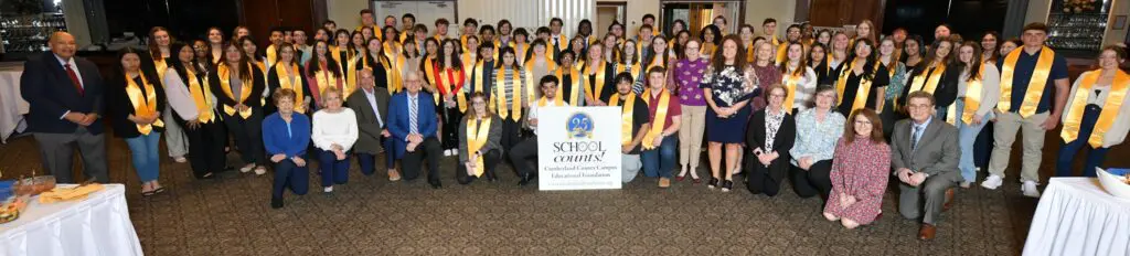 Group photo of graduates wearing yellow stoles at a School of Dentistry event.
