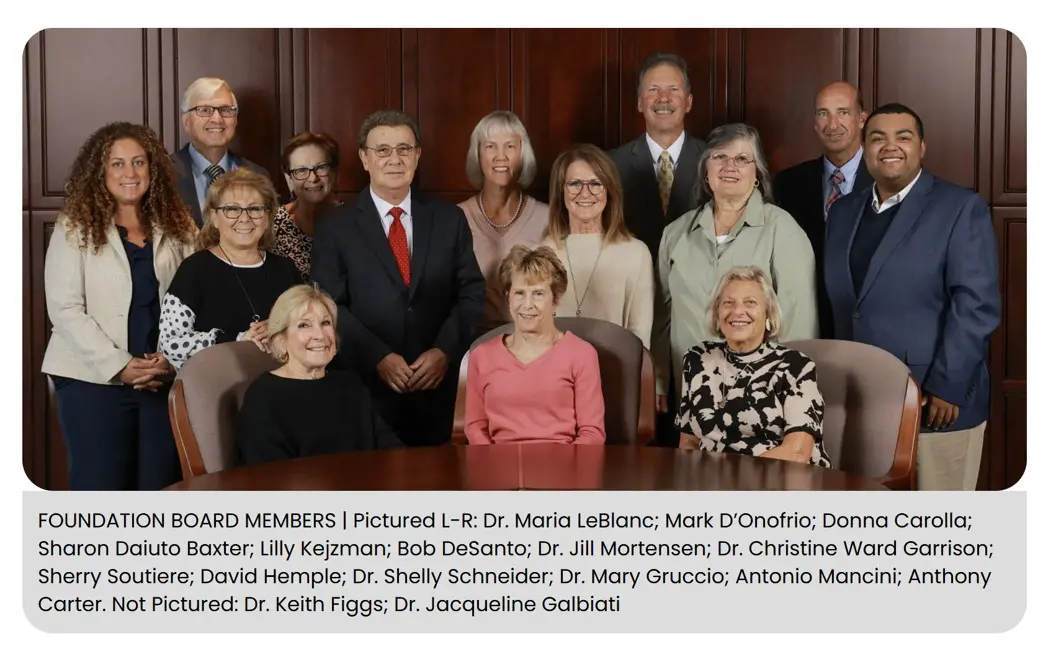 Group photo of award members posing formally in a wood-paneled room.