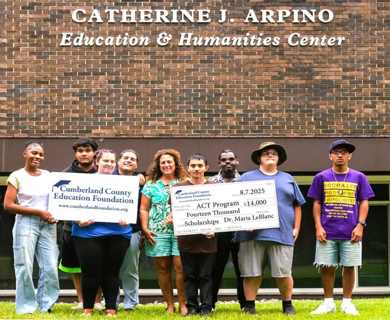 Group with scholarship checks at education center