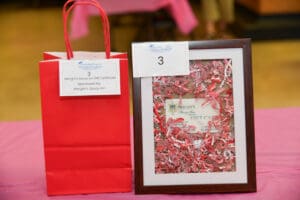 Red gift bag and framed certificate display.