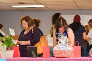 Women browsing items on a table.