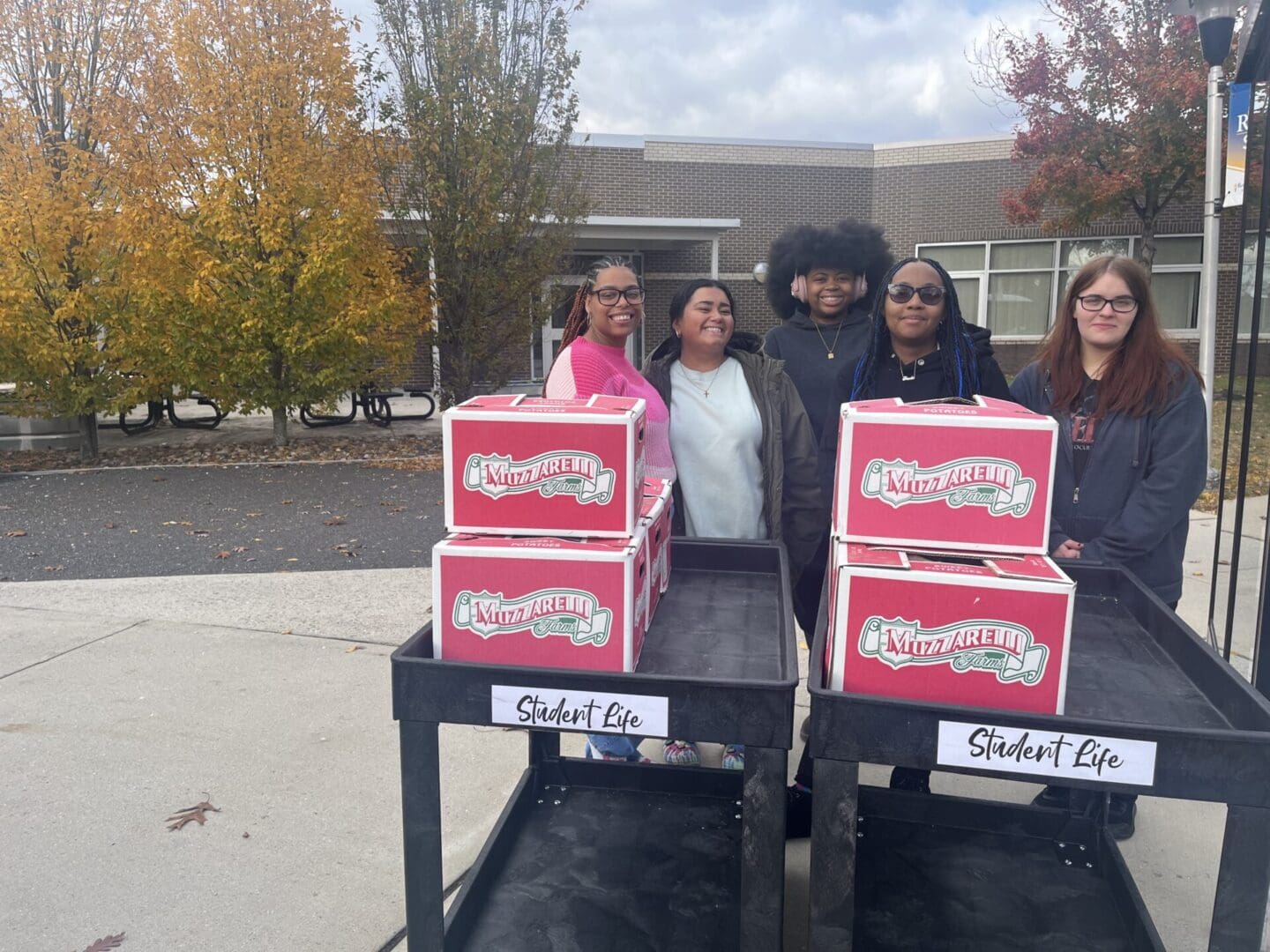 People with donut boxes on carts outside.