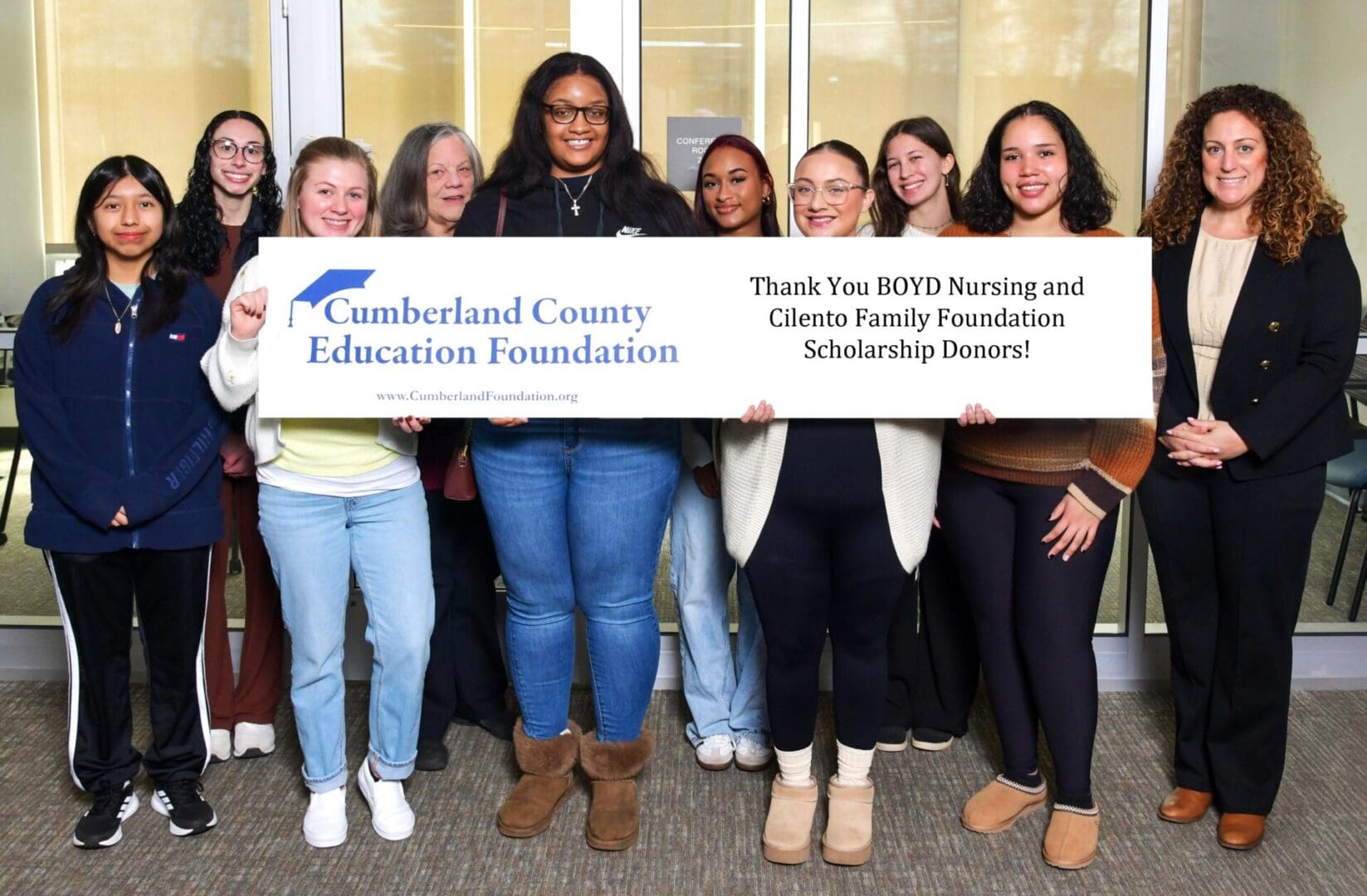 Students holding Cumberland County scholarship thank-you banner
