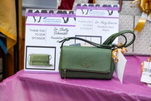 Green Kate Spade crossbody bag on table