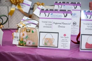 Embroidered handbag raffle display with sponsor signs