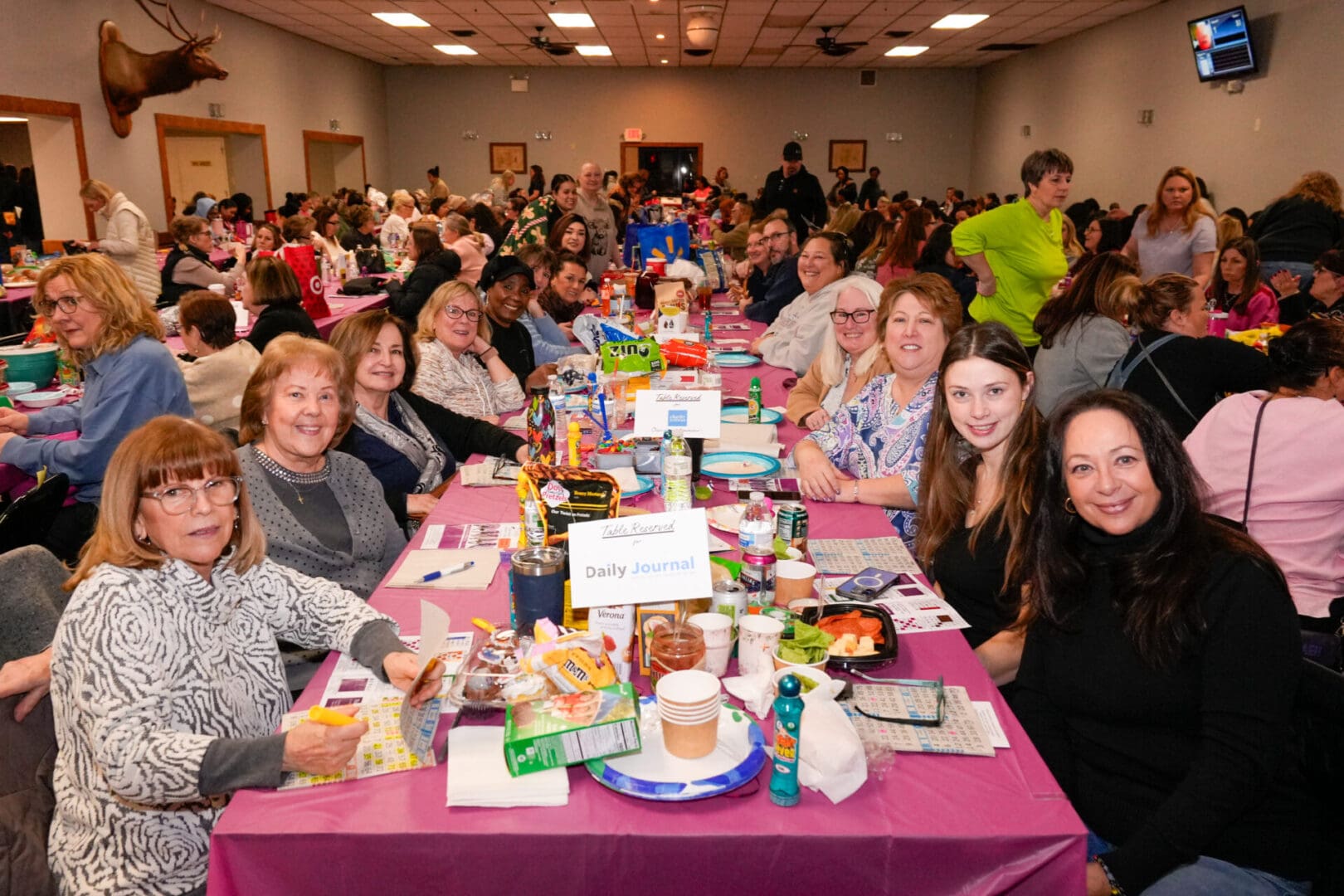 Crowded community gathering around long decorated table