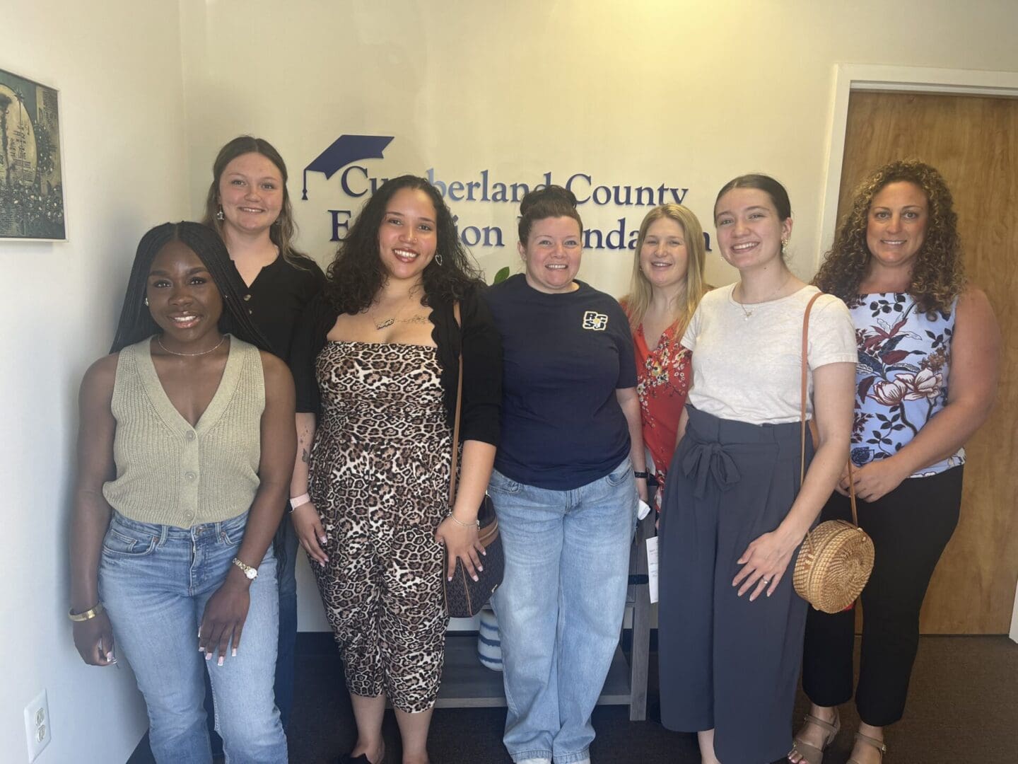 Group of seven women smiling in office